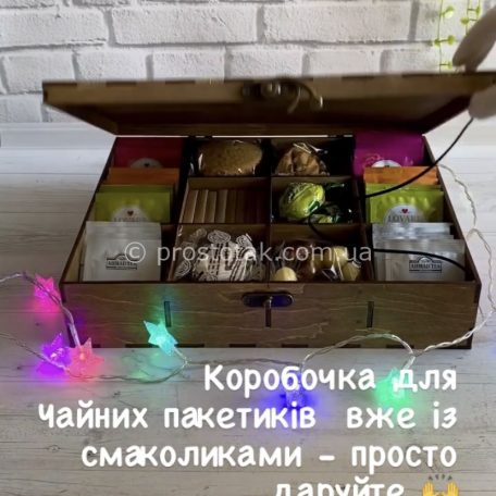 Деревянная коробка для пакетиков чая<h3><a href="https://prostotak.com.ua/ru/shop/dlya-zhenshhin/podruge/korobochka-dlya-paketikov-chaya-so-sladostyami/" rel="noopener" target="_blank">Узнать цену и заказать</a></h3>